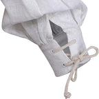 A close-up of a white textured fabric sleeve or pouch with a gathered top and a lace-up cuff made of beige rope, shown on a plain white background.