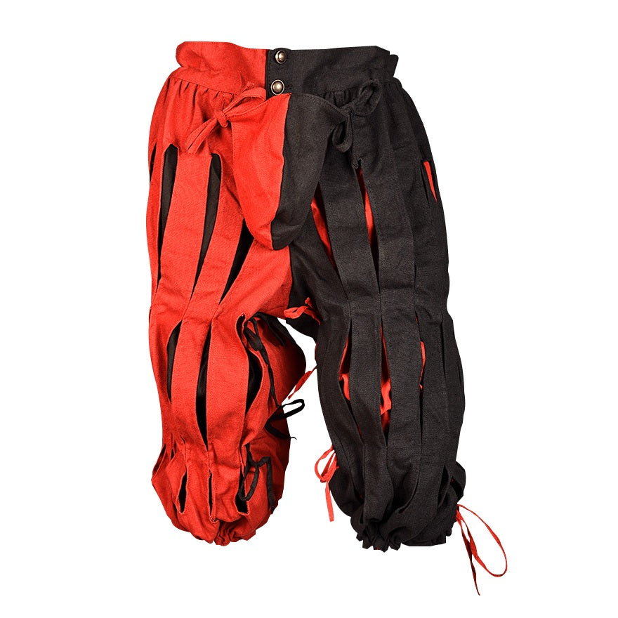 A pair of rag-style pants with one side in bright red and the other side in black, featuring long strips of fabric, drawstrings, and metal snap buttons at the waist, shown on a plain white background.